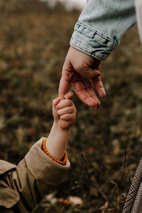 Image of a child holding a mother hand.